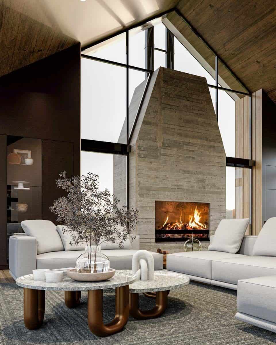 Living room with modern sofas, nesting coffee table, and a stone fireplace bordered with windows.