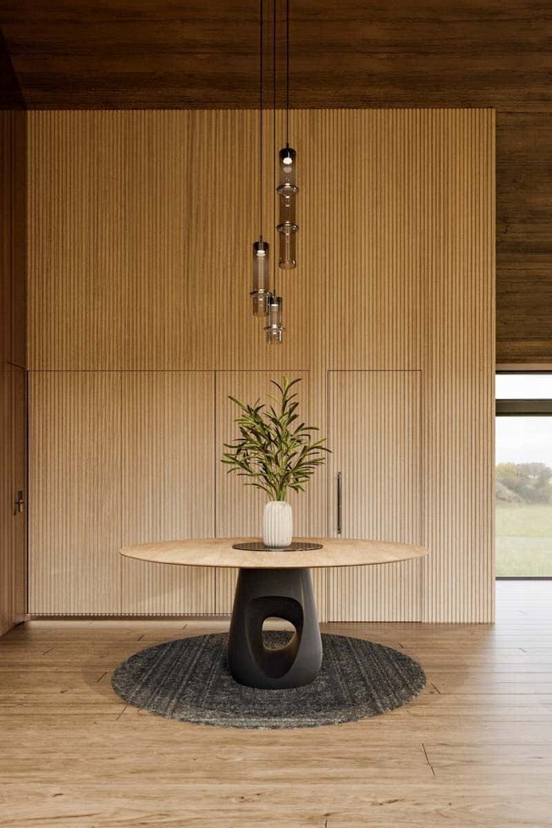 Foyer with built-in cabinets and a round center table over a round rug.