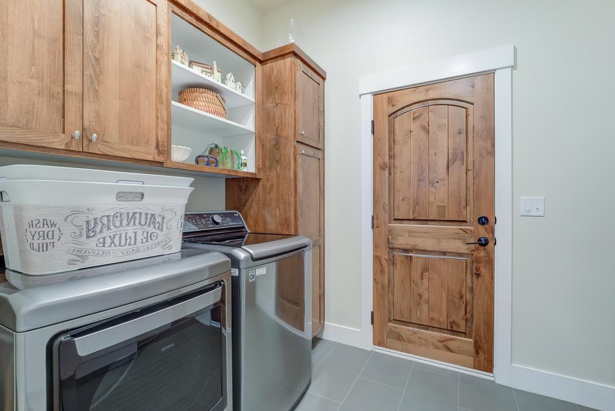 Laundry room with wooden cabinets and slate flooring.