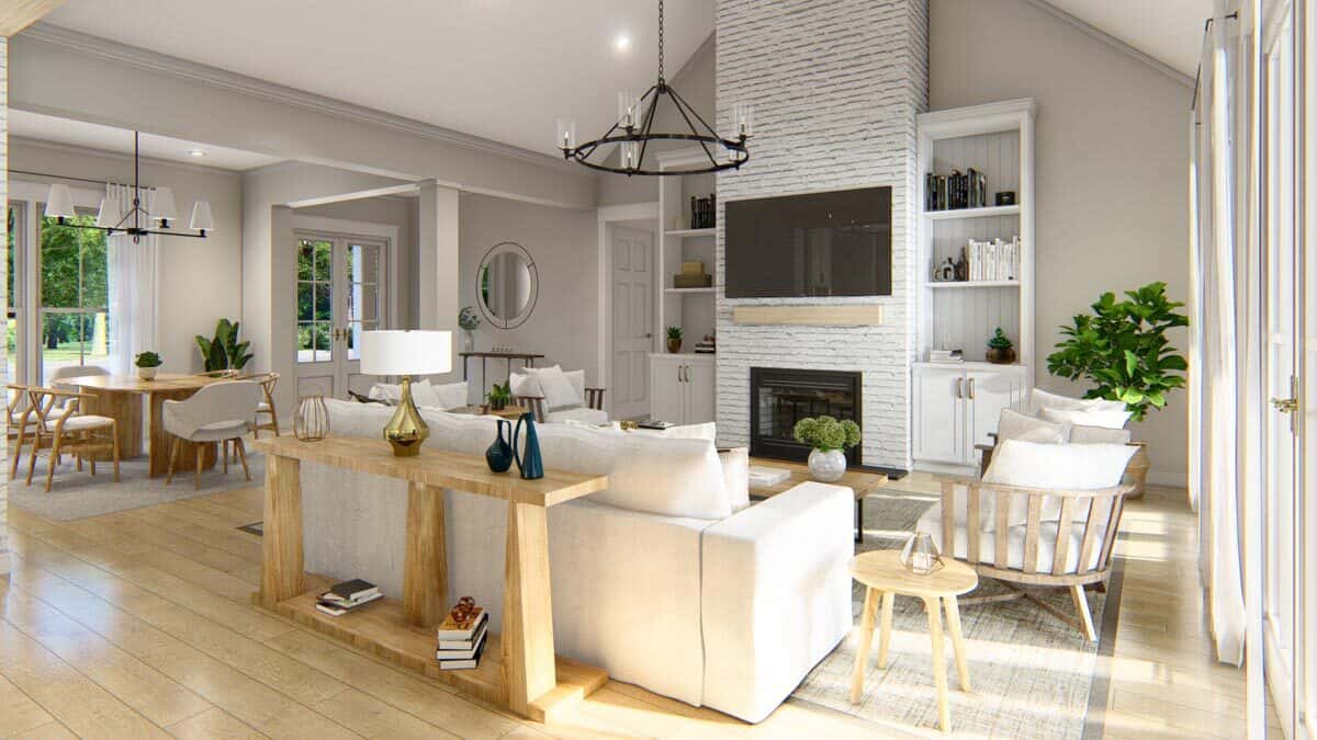 Great room with modern seats and a brick fireplace topped with a TV.
