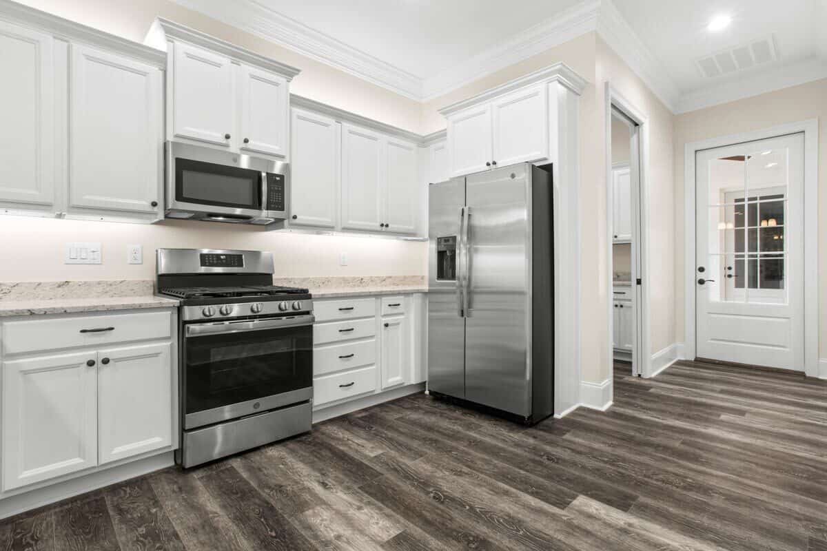 Kitchen with white cabinets, high-end appliances, and granite countertops.