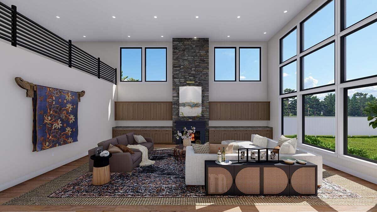 Great room with a stone fireplace and a wall of windows flooding the room with natural light.