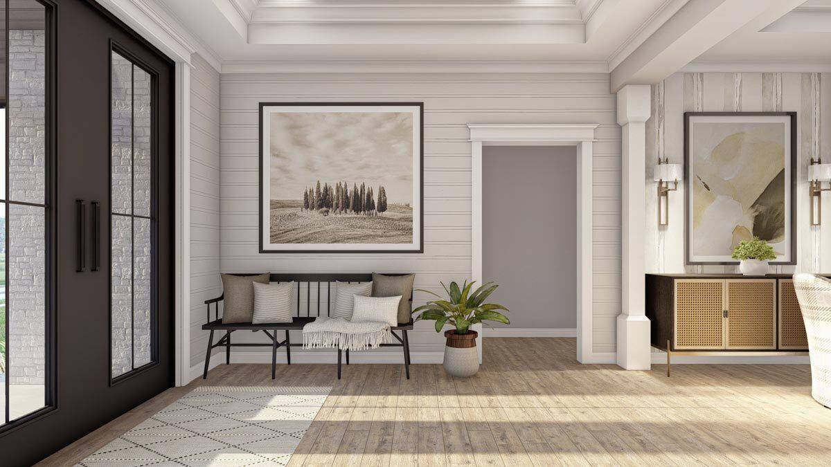 Foyer with a French front door and a dark wood bench adorned with throw pillows and a large artwork.