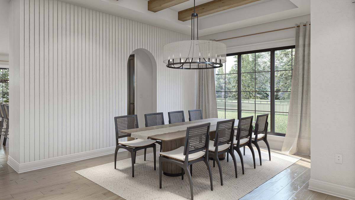 Dining room with an 8-seater dining set and a trio of windows that look out the lush yard.