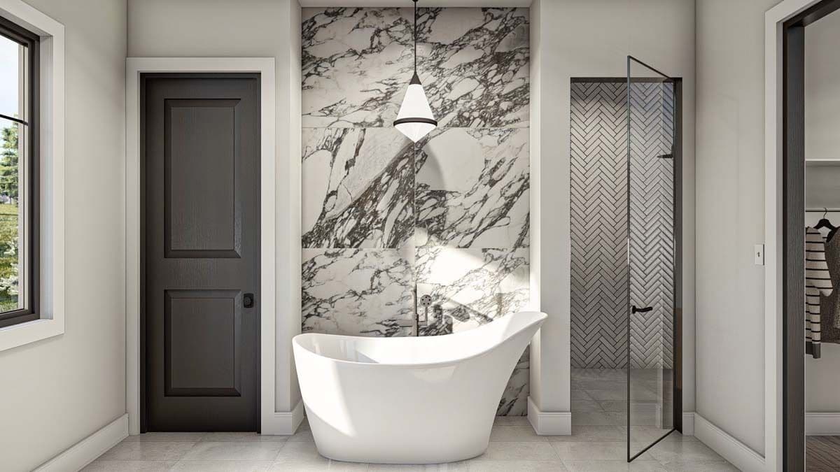 Primary bathroom with a walk-in shower and a soaking tub against the marble accent wall.
