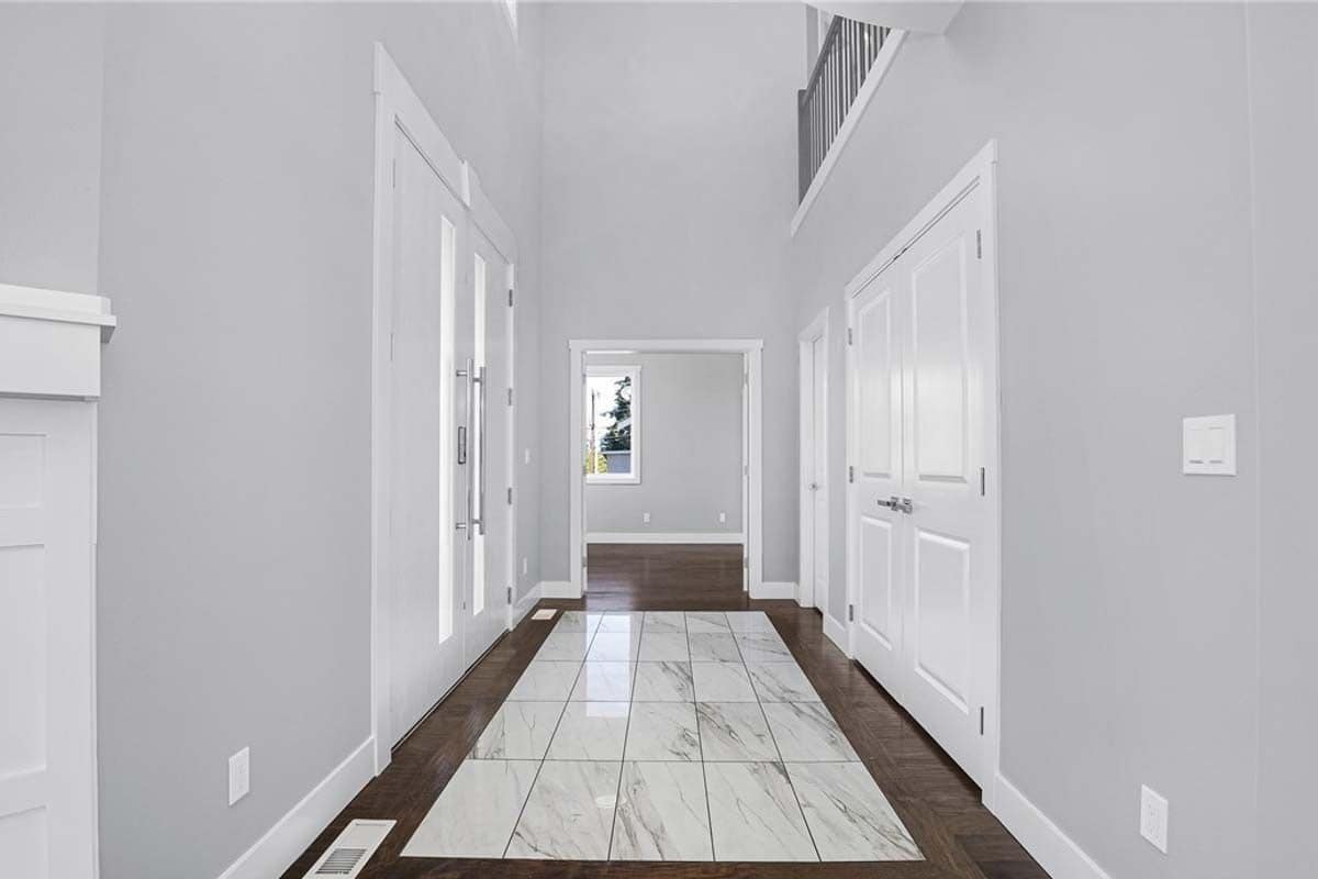 Foyer with a tiled floor and a storage closet concealed behind double doors.