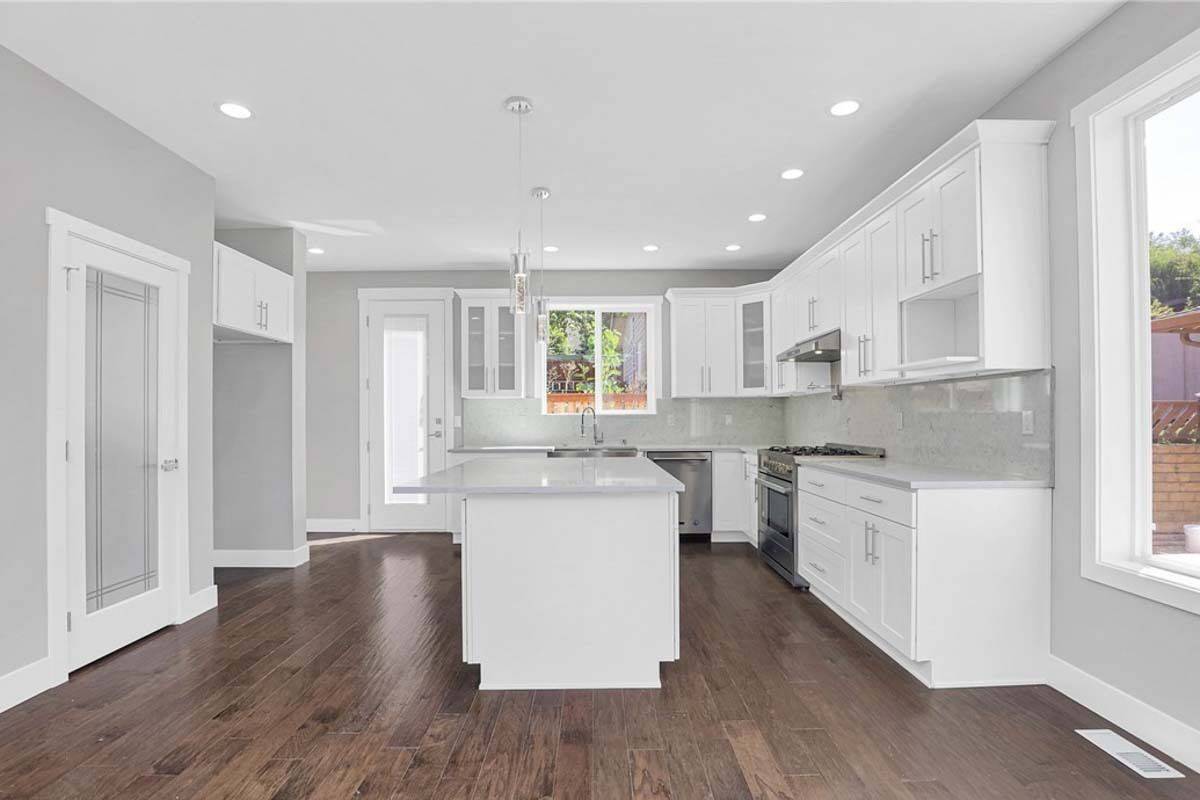 Kitchen with white cabinetry, stainless steel appliances, and a center island.