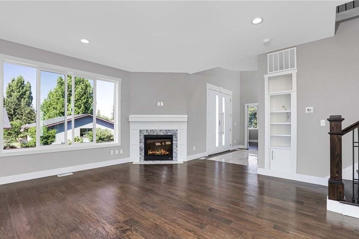 Great room with a corner fireplace, sliding doors, and a hardwood floor.