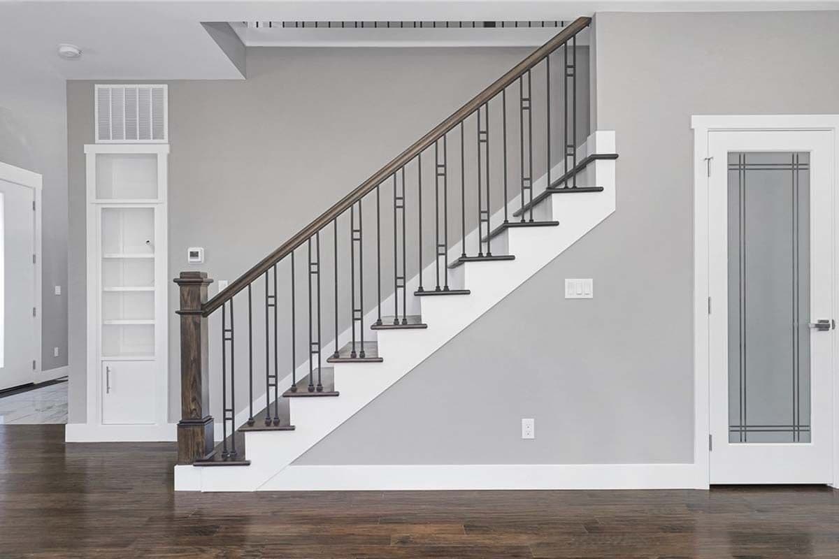 Staircase with a walk-in pantry beneath enclosed in a glazed door.