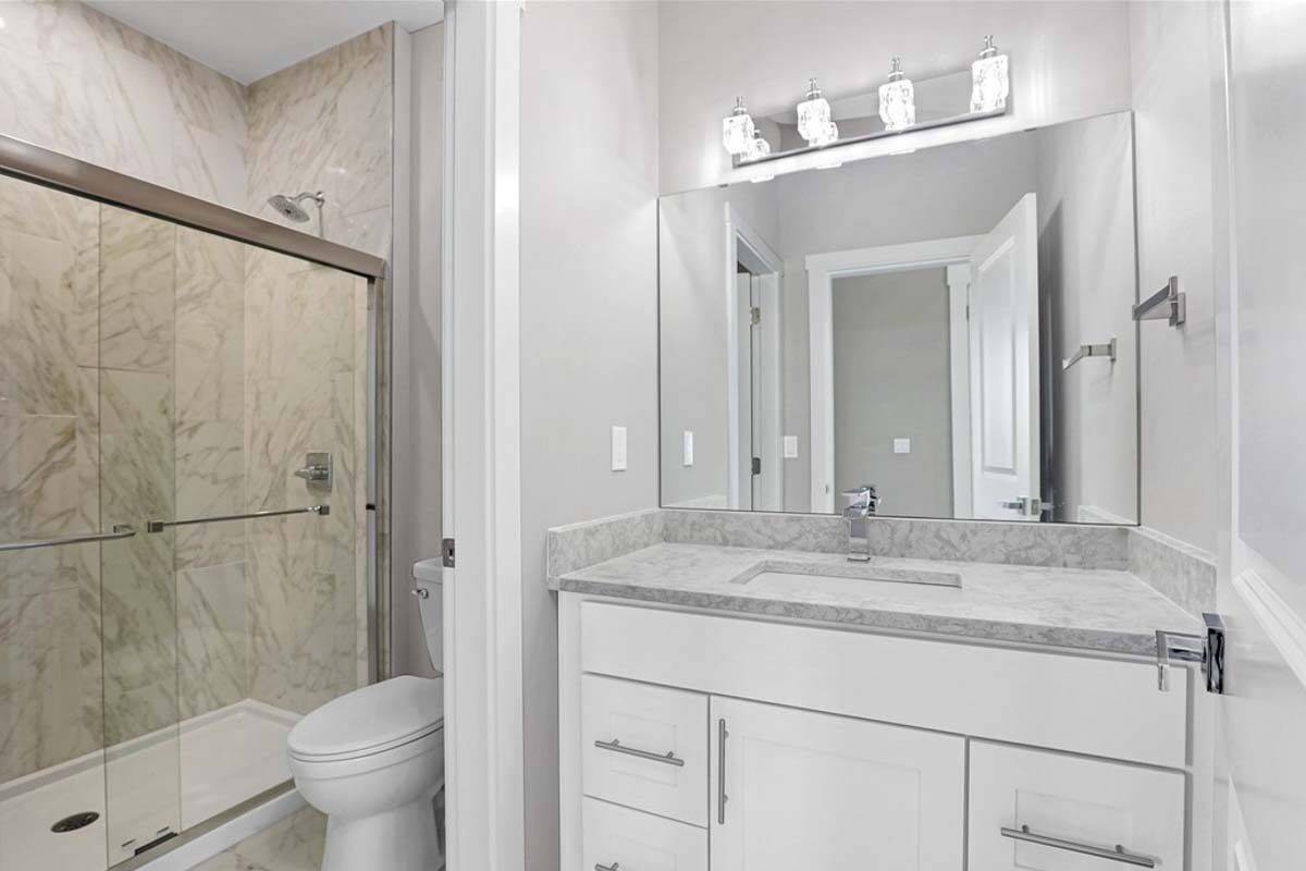 Bathroom with a sink vanity, a toilet, and a tub and shower combo.