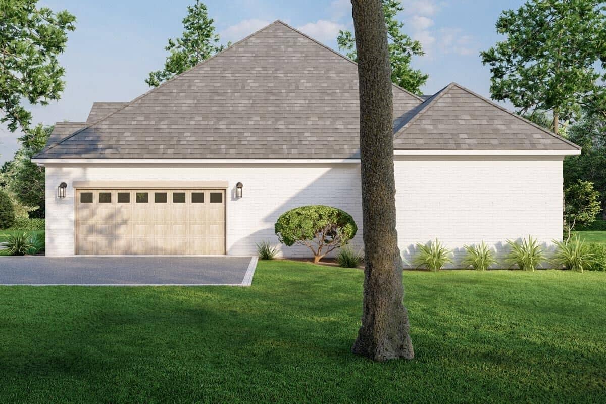 Right view of the house with hipped roofs and a double garage.