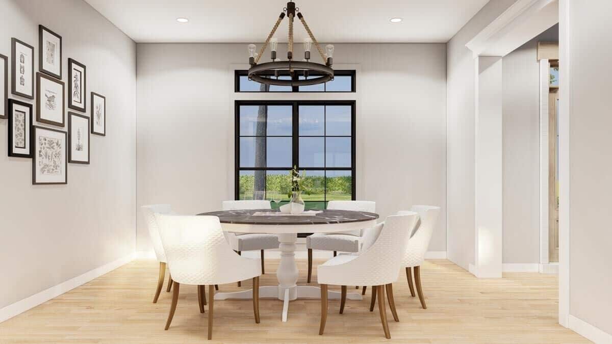Dining room with a round dining set topped with a wrought iron chandelier.