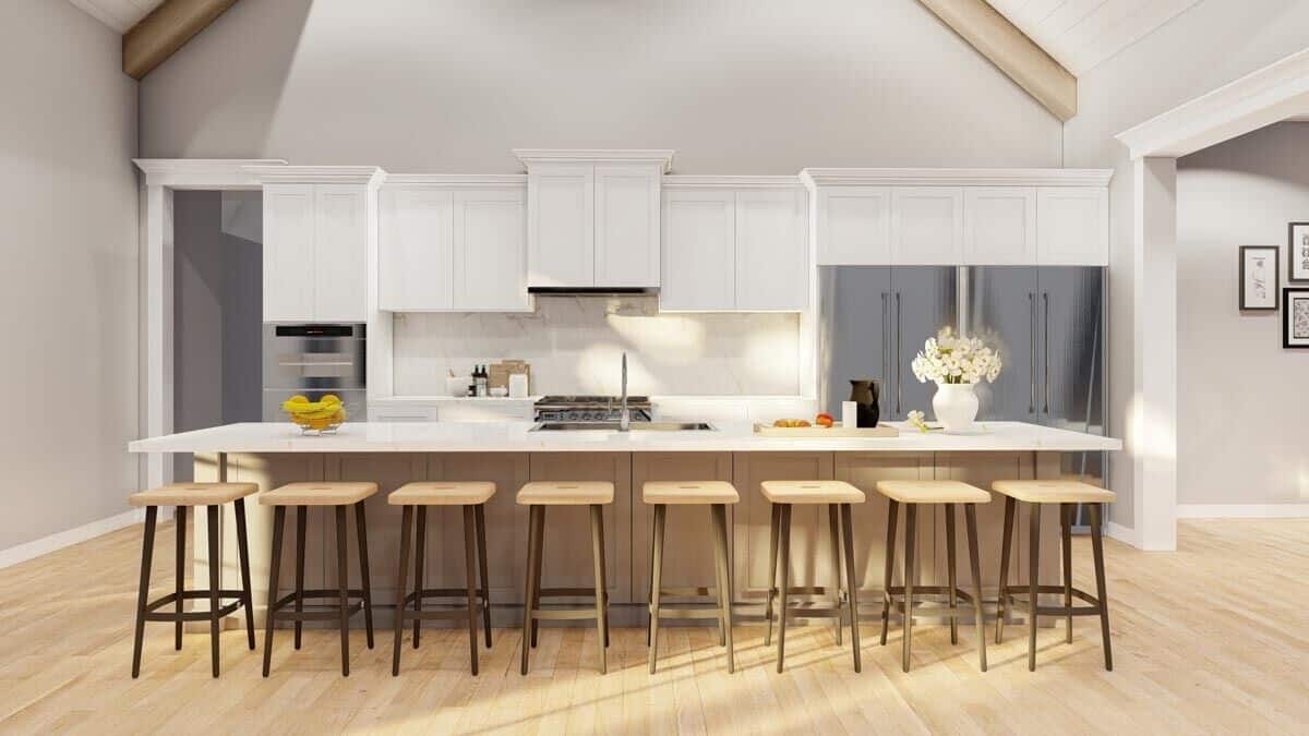 Kitchen with white cabinets, two fridges, and an elongated island with seating for eight.
