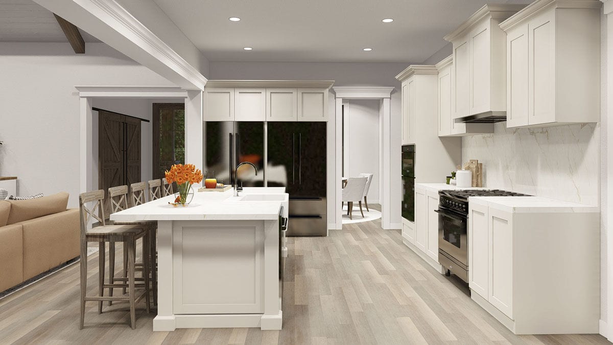 Kitchen with white cabinets, two refrigerators, and a breakfast island paired with wooden counter chairs.