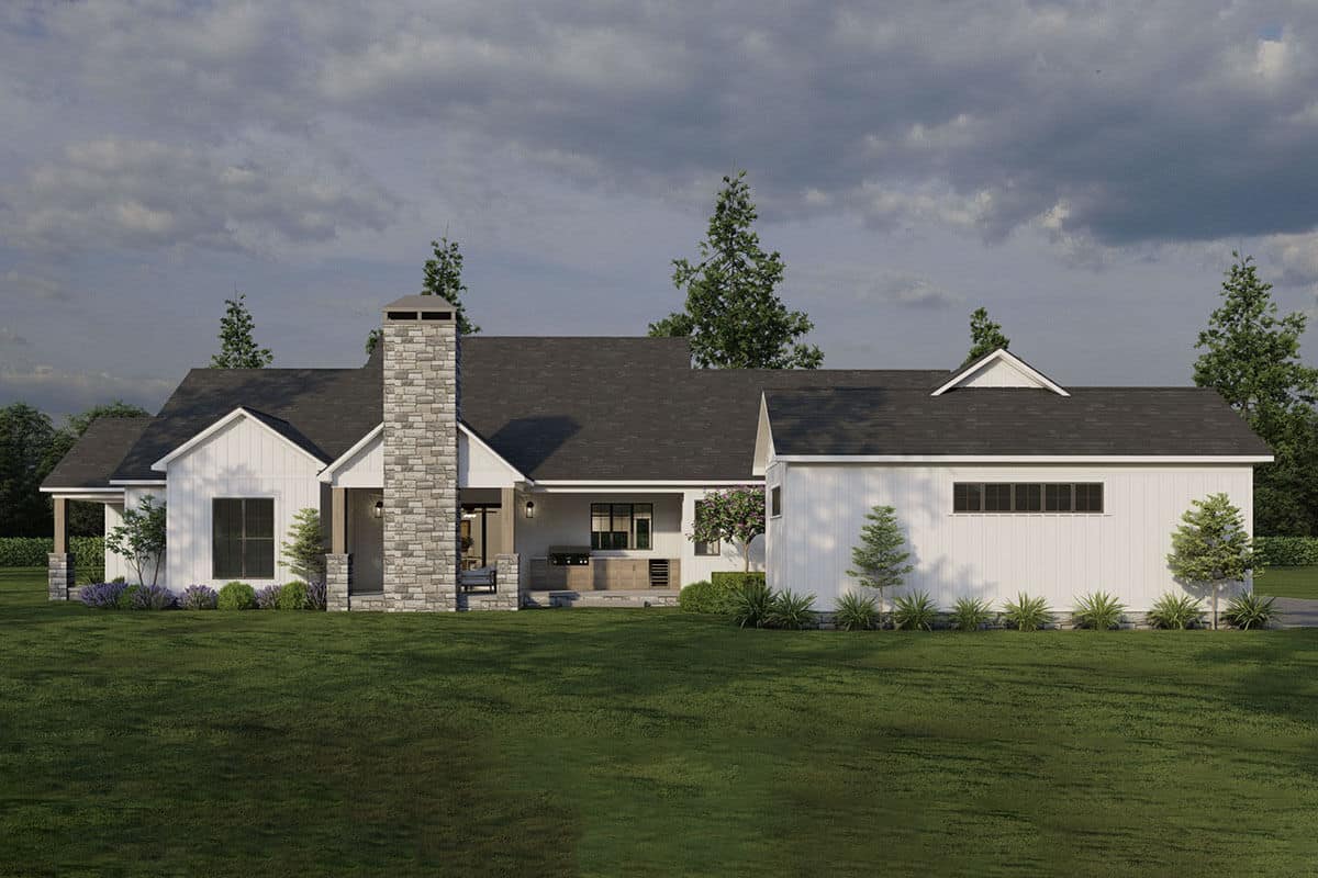 Rear view of the house with a stone chimney and a covered outdoor living.