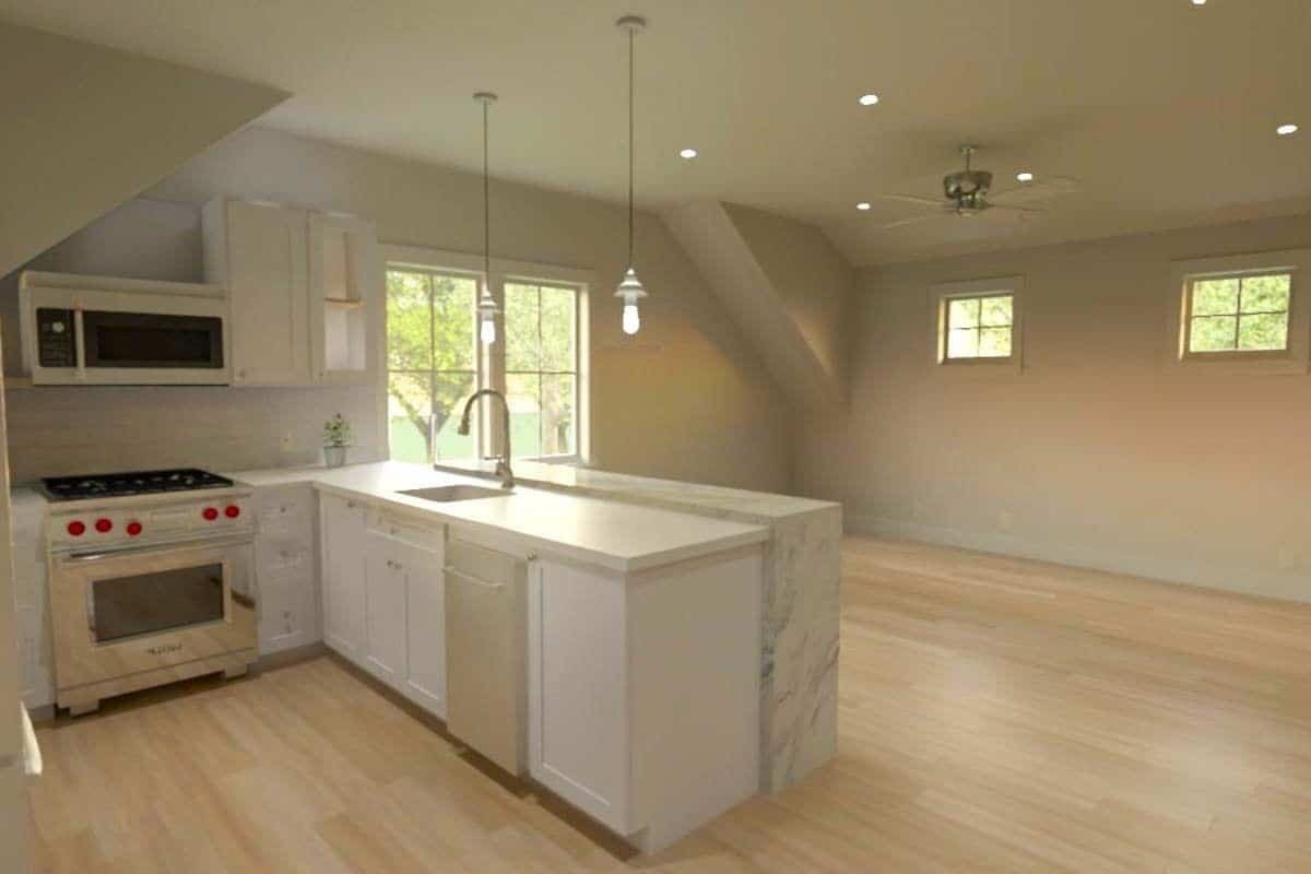 Kitchen and living area illuminated by recessed ceiling lights and clerestory windows.