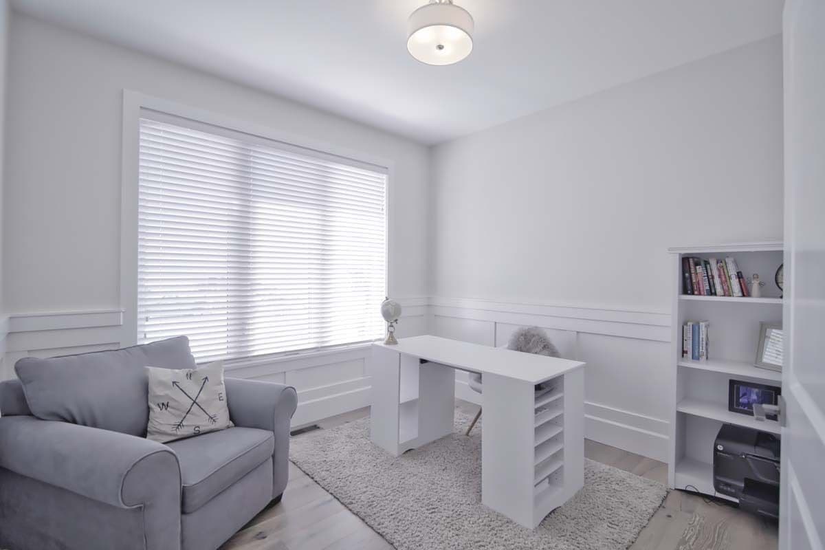 Office with a gray armchair and a white desk over a shaggy area.