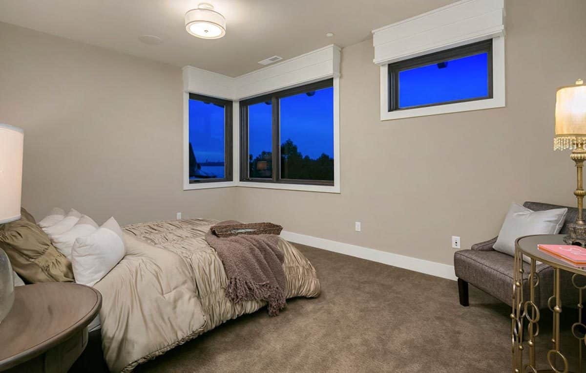 Secondary bedroom with a platform bed and a leather chair with a round table on the side.