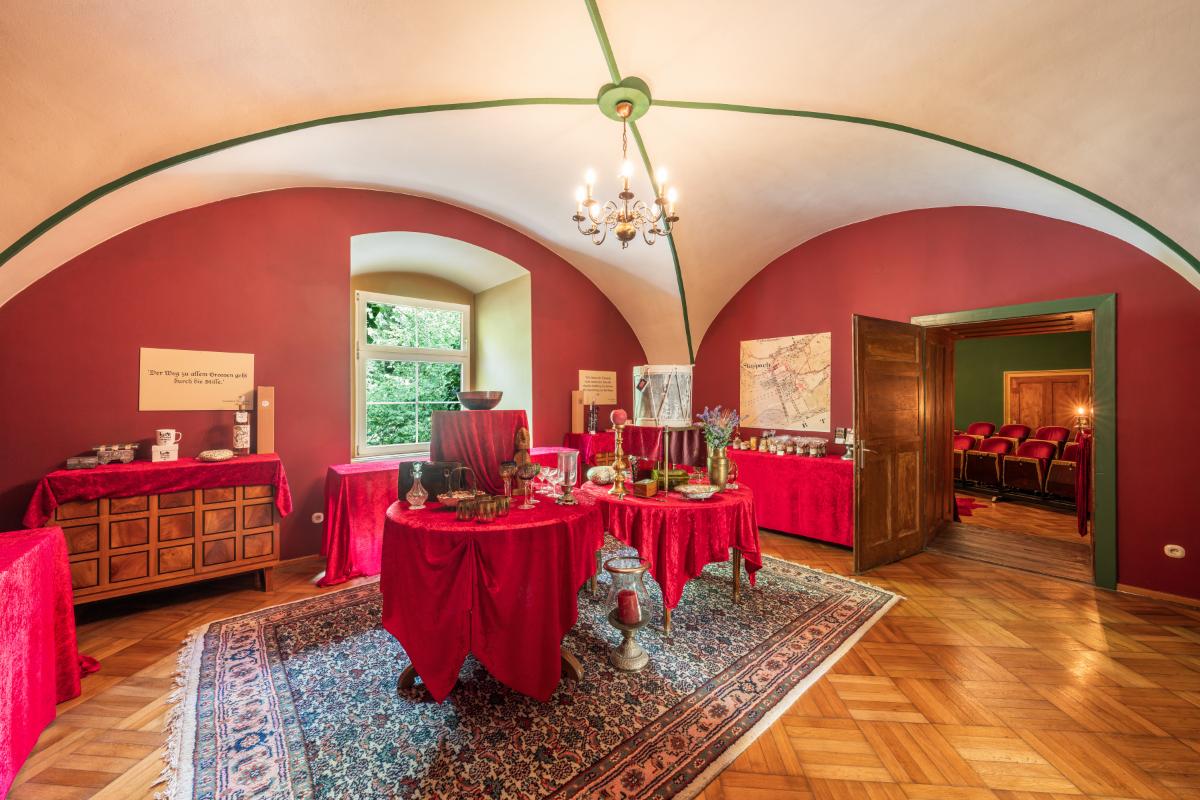 Entertainment room with tables, large rug, chandelier and glass windows.