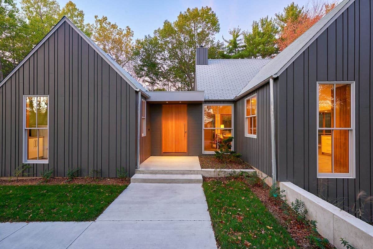 Front porch with a wooden entry door and a concrete walkway.