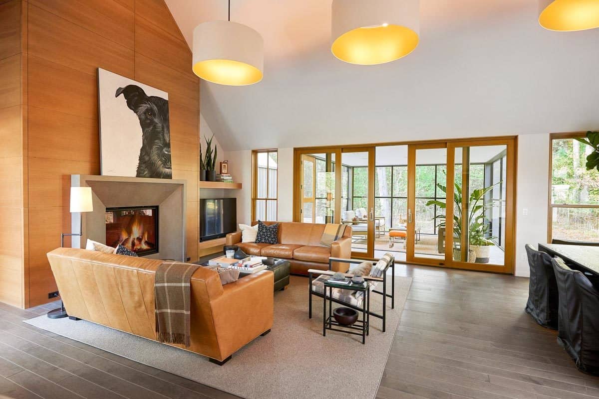 Living room with leather sectionals and a fireplace adorned with a painting.