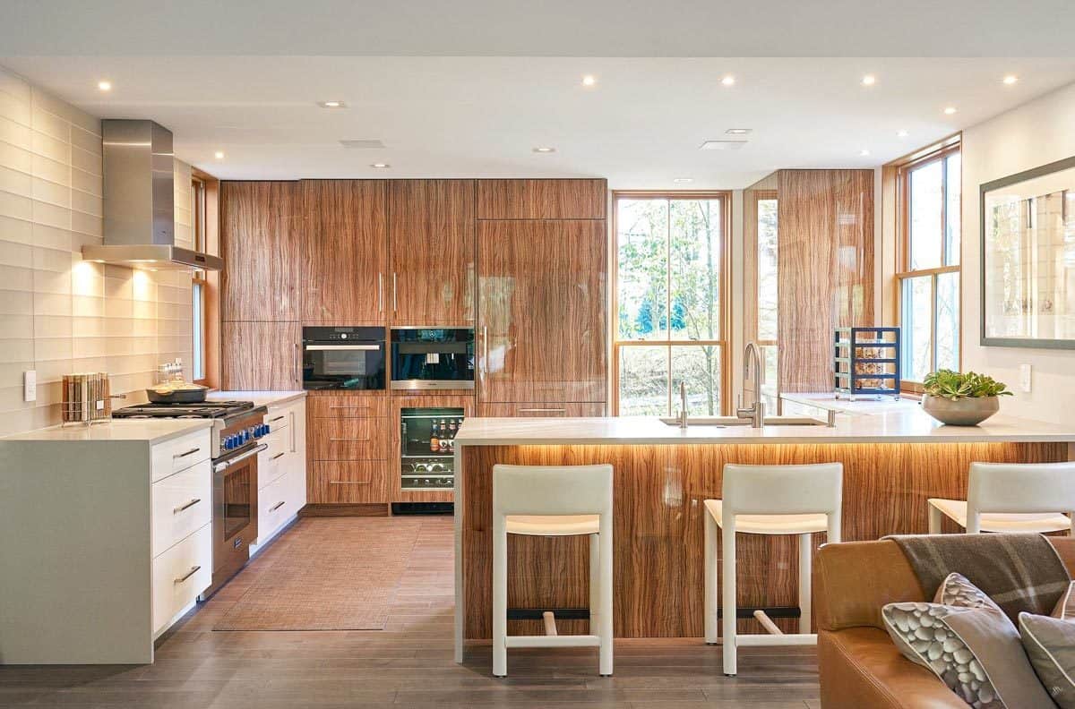 Kitchen with wooden cabinets, modern appliances, and a peninsula bar with seating for three.