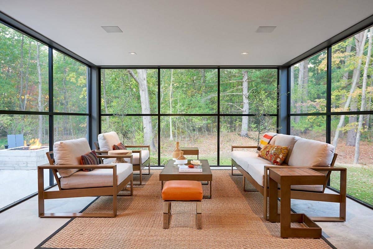Sunroom with cushioned seats, a matching coffee table, and expansive views of the backyard.