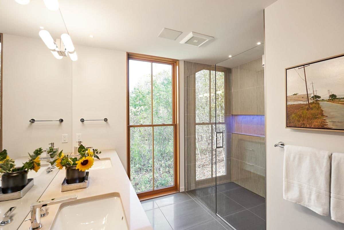 Primary bathroom with a dual sink vanity and a glass-enclosed shower.