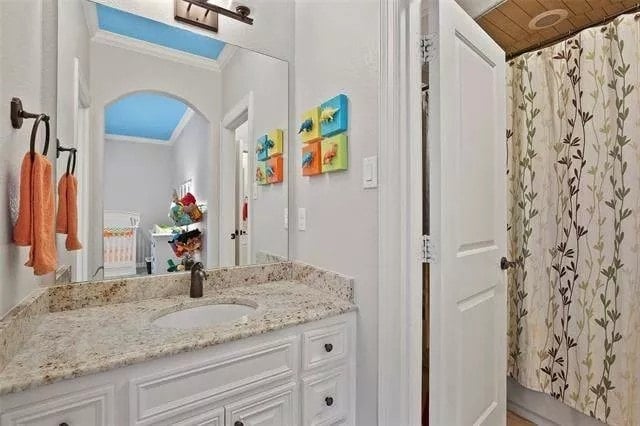 Bathroom with a sink vanity and a tub and shower combo enclosed in a curtain.
