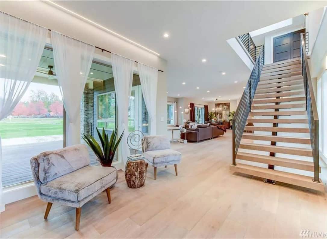 Foyer with velvet chairs and a modern staircase leading to the sleeping quarters.