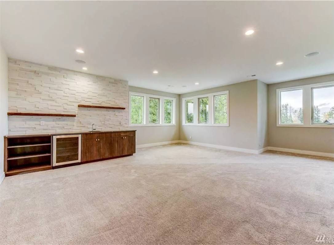 Bonus room with a carpeted floor and a wet bar with a built-in fridge.