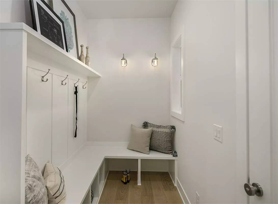 Mudroom with a built-in bench, coat hooks, and cubbies.