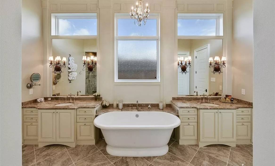 Primary bathroom with his and her vanities flanking the freestanding tub.