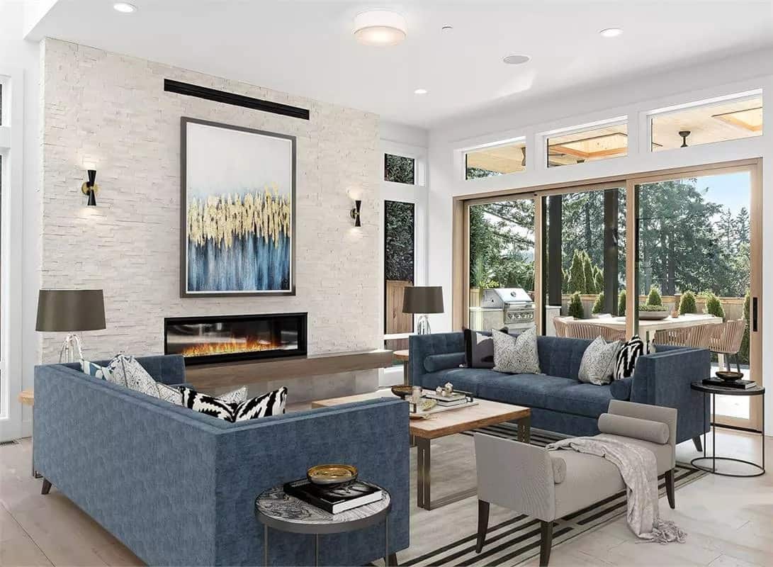 Great room with facing sofas, a wood-top coffee table, and a linear fireplace adorned with a framed artwork.