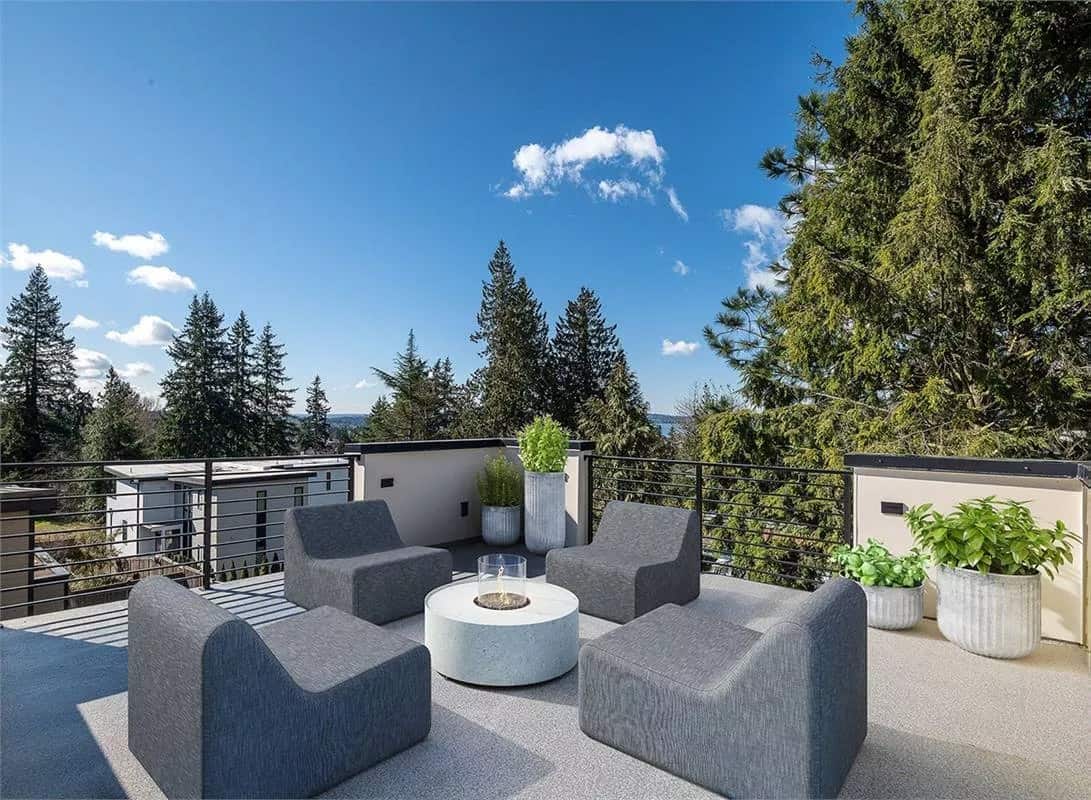 Rooftop deck with modern seats surrounding the fire pit table.