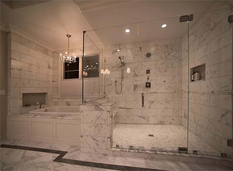 The primary bathroom includes a drop-in bathtub illuminated by a candle chandelier.