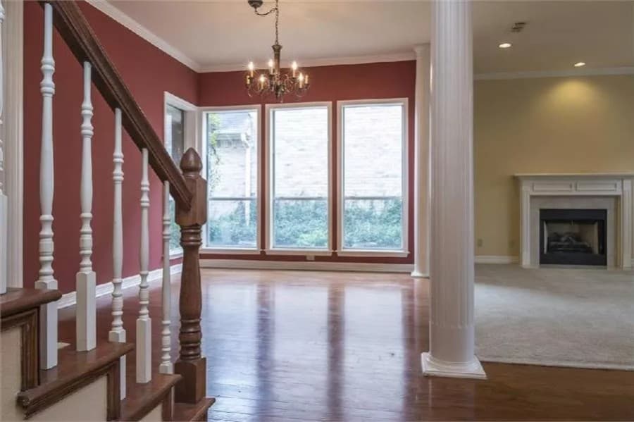 Living room and dining room with multicolored walls, a fireplace, and tall windows.