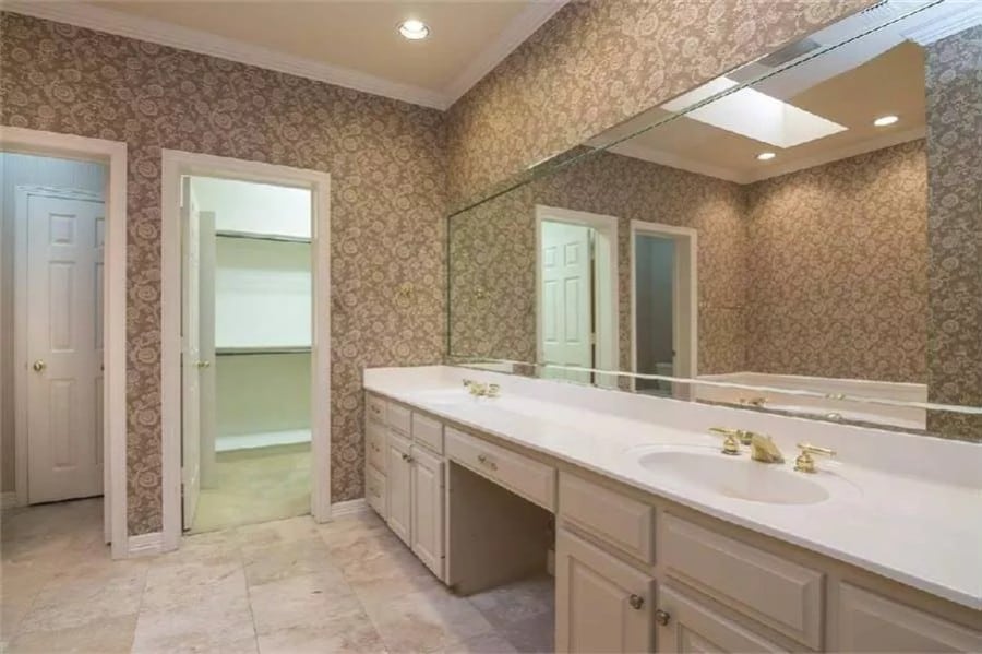 Primary vanity with two sinks, light wood cabinets, and a massive rectangular mirror.