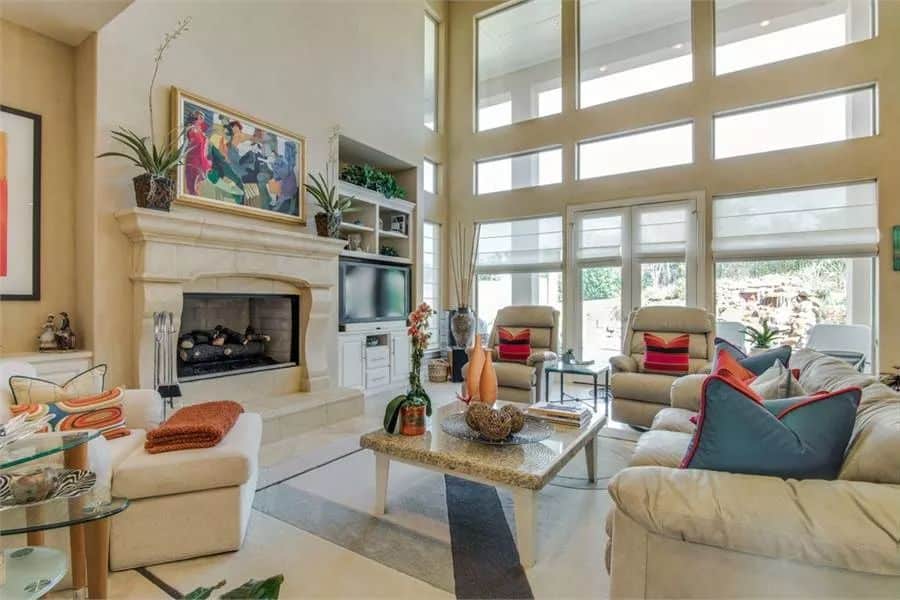 Family room with beige seats, a fireplace, and a French door that opens to a covered veranda.