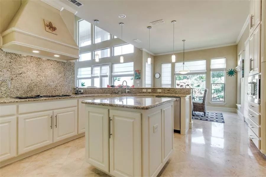 Kitchen with white cabinets, granite countertops, and a center island.