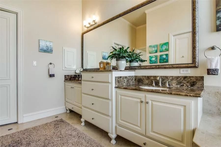 Primary vanity with two sinks, granite countertops, and a rectangular mirror.
