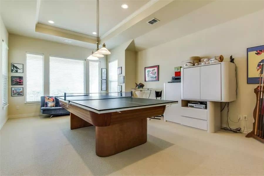 Game room with a tray ceiling, a velvet sofa, and a pingpong table.