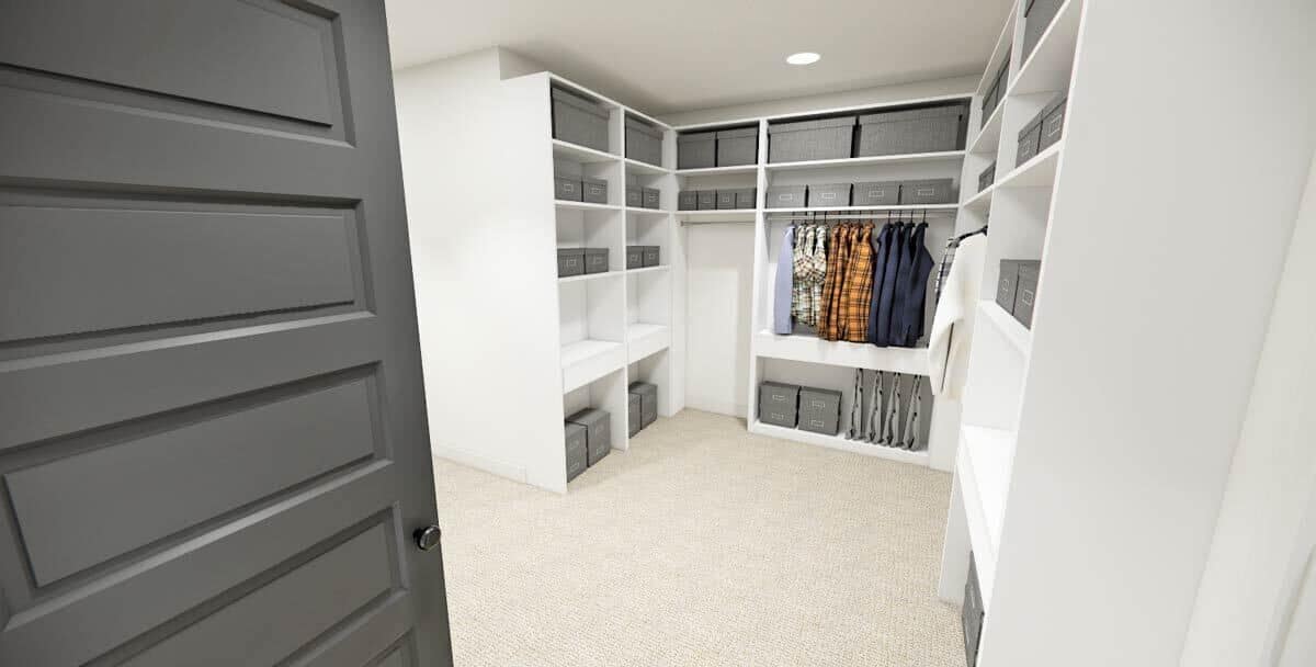 Primary walk-in closet with ample storage and a carpeted floor.