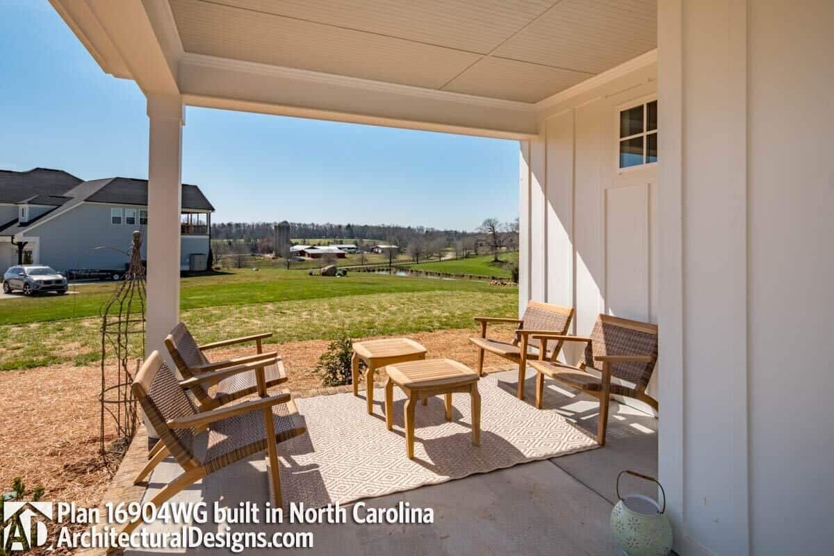 Covered porch with wicker chairs over the concrete flooring.