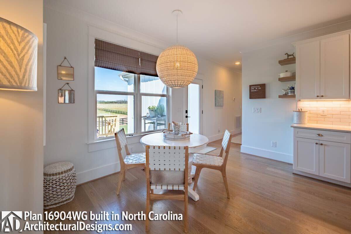 Breakfast nook with a round dining set illuminated by a spherical pendant.