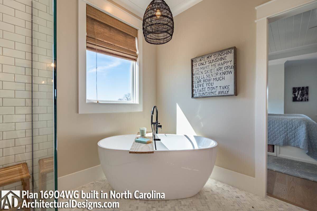 A freestanding tub under the picture window completes the primary bathroom.