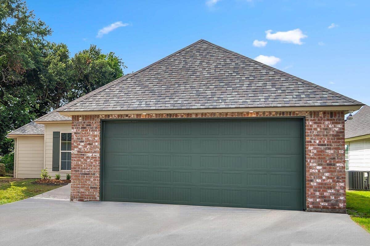 Double garage with huge paneled doors, brick walls, and a hipped roof.