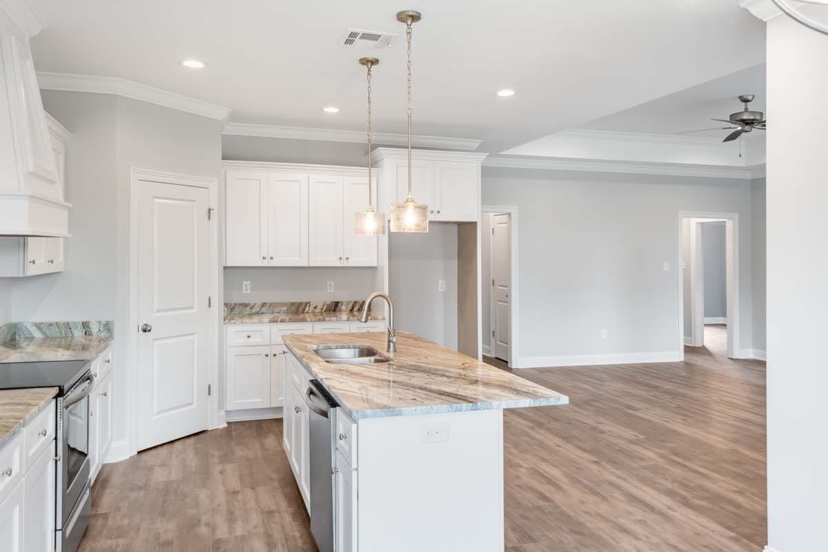 Kitchen island with double sinks and a dishwasher overlooking the living room.