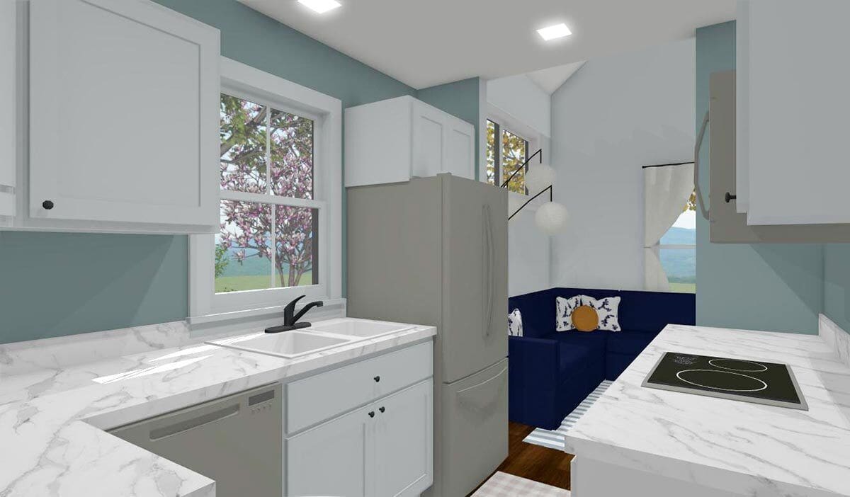 Kitchen with marble countertops, slate appliances, a built-in cooktop, and a sink set under the white-framed window.