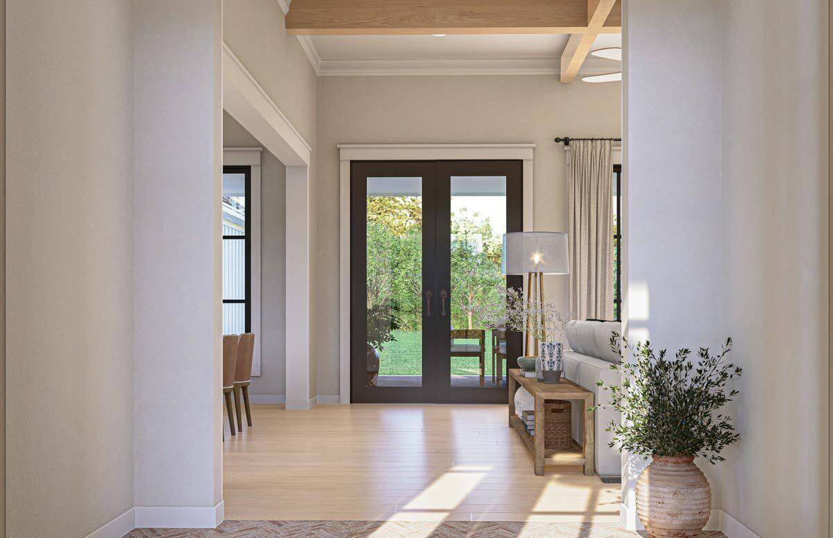 Foyer with a French entry door and a wooden console table that blends in with the hardwood flooring.